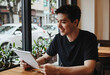 © Pixel-Shot - Smiling young man looking at a calendar in a cafe, planning and scheduling concept, urban lifestyle and daily routine