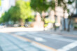 © spacezerocom - Abstract blurred modern urban street background with white arrow road markings and green trees