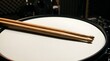 © Sophia - Wooden drumsticks resting on a snare drum head in a recording studio