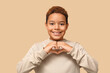 © Pixel-Shot - Cute little African-American boy showing heart gesture on brown background. Valentines day celebration