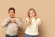 © Pixel-Shot - Cute little children showing heart gesture on brown background. Valentines day celebration