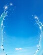 © ele - 青空と白い雲を背景に左右からアーチ状に広がる水流と輝くきらめき　Arching Water Splashes and Glowing Sparkles Framing a Clear Blue Sky