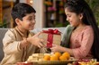 © Olga Ко - Happy Indian brother giving a beautiful gift box to his sister during Raksha Bandhan celebration. Cute siblings wearing traditional clothes with a tied rakhi bracelet and festive sweets