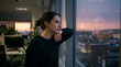 © Zainuddin - Thoughtful young woman reflecting while gazing at the urban city skyline from her office window during sunset