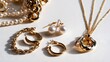© Thares2020 - Elegant gold jewelry collection featuring pearl earrings  chain necklaces  and hoop bracelets arranged on a clean white surface