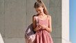 © AnastasiiaAkh - Young schoolgirl using smartphone while wearing backpack outdoors before school in modern urban setting