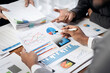 © Freedomz - A group of people are looking at a table full of graphs and charts