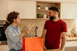 © La Famiglia - Couple unpacking takeout food delivery in kitchen
