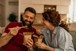 © La Famiglia - Happy couple enjoying takeout food with chopsticks at home