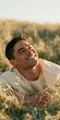© Andrii Zastrozhnov - Young man smiling relaxed in a grassy field at golden hour outdoor portrait for lifestyle background and nature wellness banner for summer marketing