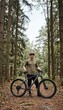 © spyrakot - Mountain biker standing with bicycle in forest trail