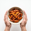 © Lari - Close up of hands holding a bowl of glazed roasted baby carrots seasoned with fresh thyme and black pepper