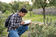 © Edgar - Student Observing Nature in the Park. A Latino high school student observing native plants in a green park for a biology project