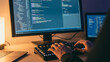 © MD. NOWSHER ALI - Programmer typing software code on computer monitor in dark room