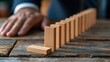 © The Little Hut - Business executive stopping falling dominoes in a chain reaction, symbolizing risk management and decision making