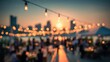 © Rajnikant - rooftop party blurred background sunset city skyline bokeh string lights outdoor social event evening gathering celebration night city atmosphere