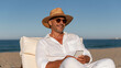 © ArtShop - Stylish man relaxing on the beach while using his smartphone