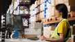 © DC Studio - Asian warehouse support clerk joins a customer video call to resolve an order mix-up or shipment delay, discussing cargo details during an online conference from the logistics workplace.