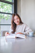 © Farknot Architect - Vertical portrait image of a woman reading a book with coffee cup on the table