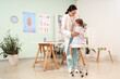 © Pixel-Shot - Female osteopath working with little patient in clinic, back view
