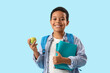 © Pixel-Shot - Little African-American schoolboy with books and apple on light blue background
