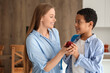 © Pixel-Shot - Mother giving apple to little schoolboy in kitchen