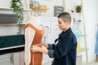 © Kawee - Caucasian woman with shaved head hairstyle working as fashion designer in studio.