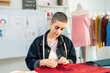 © Kawee - Caucasian young woman working as fashion designer in tailor studio.