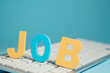 © Artvibe - Job word with computer keyboard on blue background. Job search and recruitment concept.