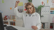 © Krakenimages.com - Woman pediatrician raising a celebratory fist while holding patient papers at a childrens clinic building; relief joy success.