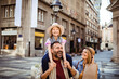 © Davor - Father carrying daughter as family shops on city street