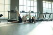 © ultramansk - Fit mom exercising with her cute child raise straight legs high lying on their sides during a family workout in a modern sunlit fitness studio. Healthy active lifestyle of a modern family