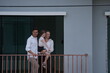 © ultramansk - Young parents holding their child greet the neighborhood from the balcony with their daughter on the balcony of their new house overlooking the residential estate