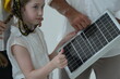 © ultramansk - Young parents teaching their curious child show the child every detail of the small solar panel inside their new energy efficient home. Renewable energy and sustainable living concept