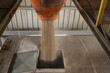 © Travel 'n' Lifestyle - View of grain being poured from an orange industrial hopper into a metal container in a processing facility in Nairobi, Nairobi County, Kenya.