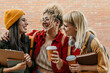 © La Famiglia - Diverse students laughing sharing coffee on campus