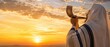 © Olga Ко - Religious Jewish man wrapped in a tallit blowing the shofar horn against a dramatic sunset sky. Background concept for Rosh Hashanah (Jewish New Year), Yom Kippur and High Holy Days.