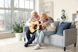 © Pixel-Shot - Mature couple playing guitar at home
