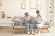 © Pixel-Shot - Mature woman after chemotherapy with doctor at home. Stomach cancer concept