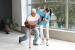 © Pixel-Shot - Sick senior man with stick and nurse in hospital hallway