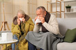 © Pixel-Shot - Sick mature couple with tissues sneezing at home