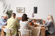 © Pixel-Shot - Happy family praying before dinner at festive table on Thanksgiving Day