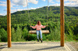 © bondarillia - Person swings on a swing set overlooking a green hill