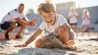 © CreativeArt - Boy athlete happily landing in a sand pit after a long jump, training with coach and teammates on a sunny day
