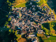 © Amazing Aerial - Aerial view of the Dieng Plateau village nestled among terraced agricultural fields and lush green mountains in Indonesia.