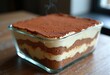 © Yaroslava - Layered Tiramisu Dessert Elegantly Presented in Glass Casserole Dish with Cocoa Dusting