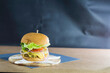 © youness - Classic cheeseburger on wooden platter with large copy space