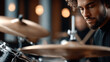 © syhin_stas - Young male jazz drummer focused on playing rhythmic beats, performing with talent and musical expression on his drum kit in a dimly lit studio or club environment