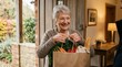 © spyrakot - Senior woman receiving fresh groceries at home entrance