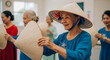 © SYATRI RAWU - Portrait of a happy senior Vietnamese woman wearing a non la conical hat while participating in a traditional folk dance performance with others.